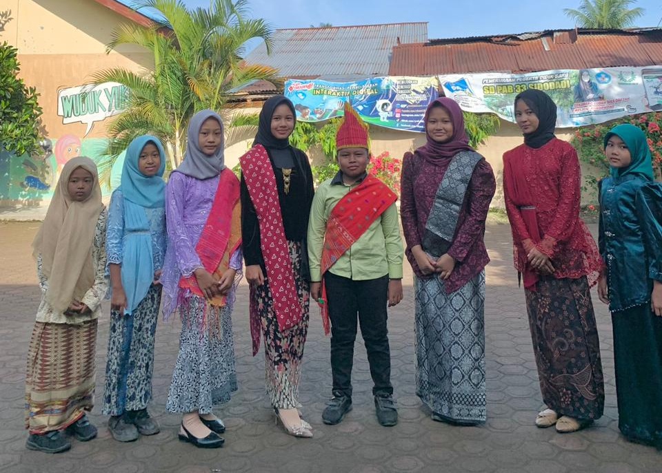 Generasi Pancasila: Mengenakan busana tradisional, para murid berdiri tegap di halaman sekolah, siap menjaga dan mengamalkan nilai-nilai luhur Pancasila dalam kehidupan sehari-hari.